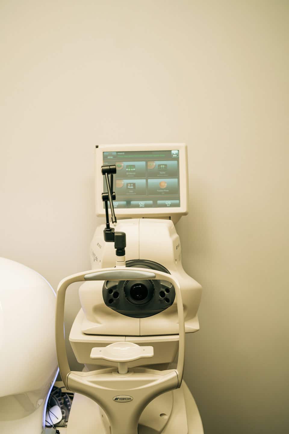 Modern ophthalmic examination machine sits against a plain wall.